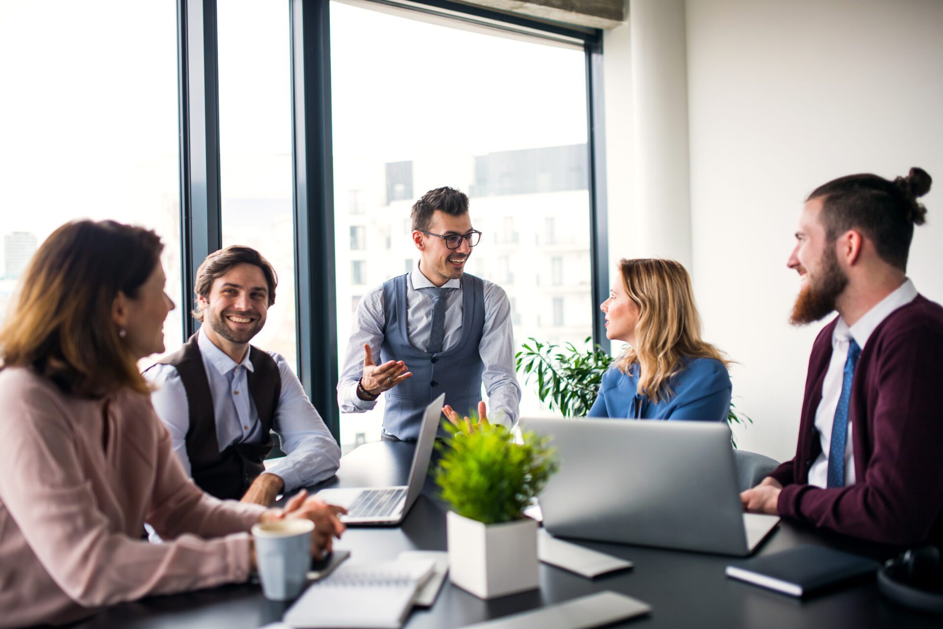 A group of young business people sitting and talking in an office, having meeting.